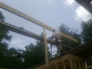 Carpenter setting a ridge beam over a new addition frame — Ice Dam Removal by Roofing Brothers in Cerritos