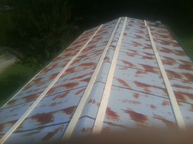 Rusted metal roof panels with new wood purlins before replacement — Storm Damage Roof Repair in Cerritos by Roofing Brothers