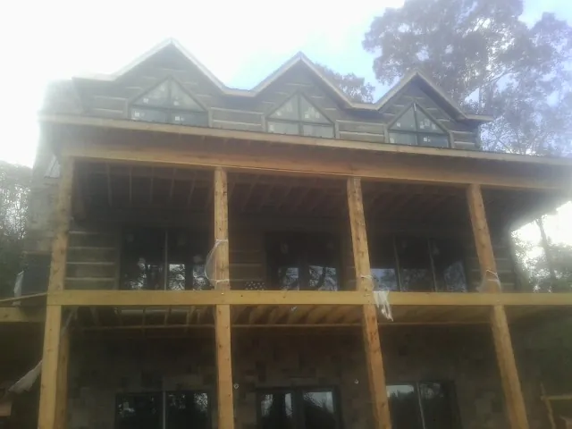 Dormers and porch framing on a large log home under construction — Roof Coating work by our crew in Cerritos