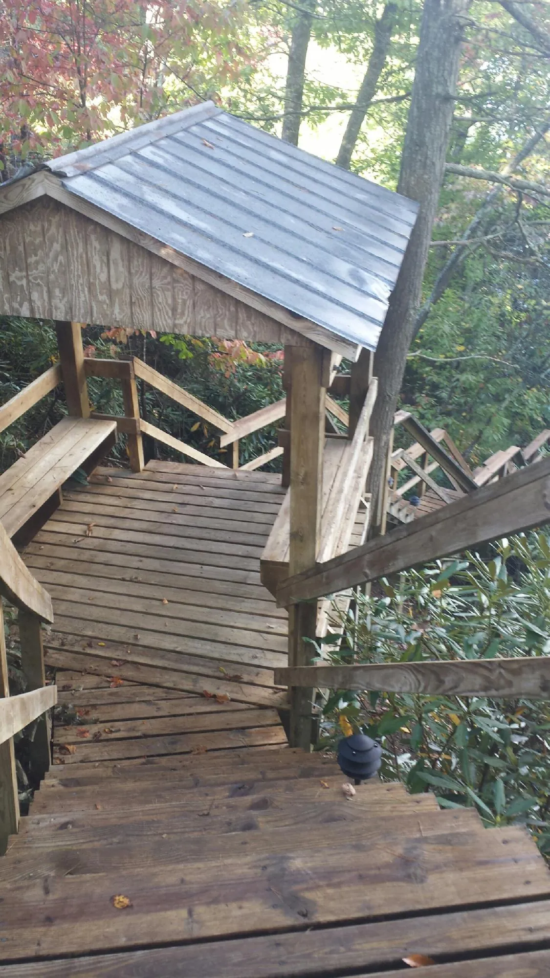 Metal roofed shelter over wooden steps on a wooded walkway — Skylight Repair & Installation work by our crew in Cerritos